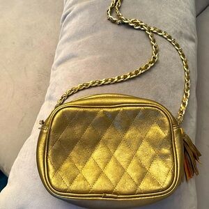Shoulder or cross body bag in gold leather with gold chain.